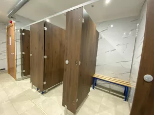 Changing cubicles with wooden doors and white marble-effect walls at Firtree Swimming near Sedgefield. Supplied by Epcot Cubicles Darlington 01325 366666 sales@epcotcubicles.com